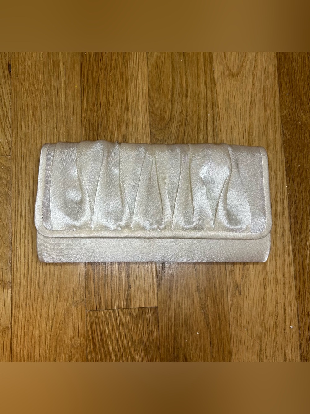 Charming Charlie cream satin clutch with pleated detailing